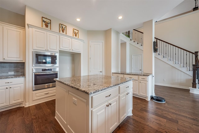 14062 Dunsmore Landing Dr, Houston, TX 77059 - kitchen featuring stainless steel appliances, light stone counters, dark wood-style flooring, white cabinets, and recessed lighting