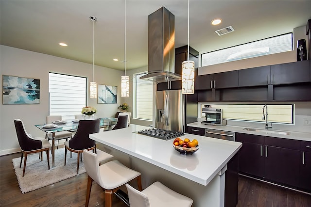 5638 Petty St Unit B, Houston, TX 77007 - kitchen with light countertops, a kitchen island, dark wood-style floors, a kitchen bar, and appliances with stainless steel finishes