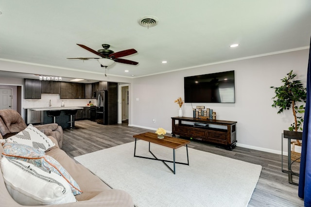 107 Sage St, Lake Jackson, TX 77566 - living room featuring wood finished floors, a ceiling fan, recessed lighting, and crown molding
