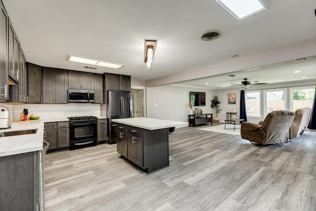 107 Sage St, Lake Jackson, TX 77566 - kitchen with stainless steel appliances, light wood finished floors, open floor plan, a center island, and backsplash