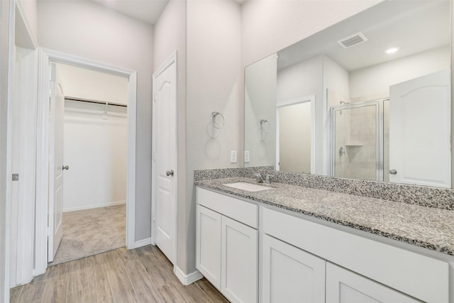 25707 Boxwood Hedge Ln, Tomball, TX 77375 - bathroom featuring a walk in closet, a stall shower, vanity, and wood finished floors