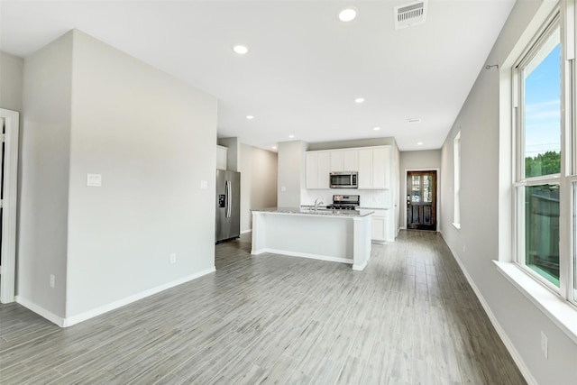 25707 Boxwood Hedge Ln, Tomball, TX 77375 - kitchen featuring stainless steel appliances, healthy amount of natural light, light wood finished floors, white cabinets, and recessed lighting