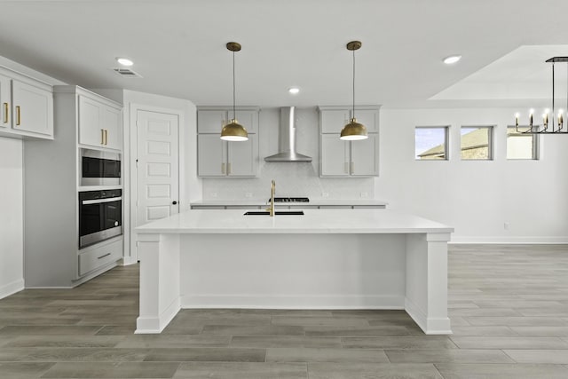 5021 Steady Breeze Dr, Katy, TX 77493 - kitchen featuring wall chimney exhaust hood, stainless steel appliances, recessed lighting, light wood finished floors, and light countertops