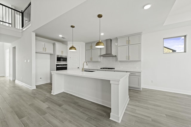 5021 Steady Breeze Dr, Katy, TX 77493 - kitchen featuring wall chimney exhaust hood, stainless steel microwave, black oven, stovetop, and light countertops