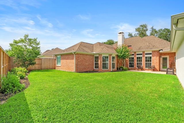 21403 Wild Jasmine Ln, Katy, TX 77450 - rear view of house with a fenced backyard, brick siding, a patio, a chimney, and roof with shingles