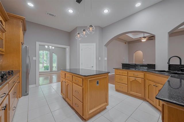 6210 Mahogany Way, Magnolia, TX 77354 - kitchen with freestanding refrigerator, a ceiling fan, arched walkways, a kitchen island, and dark stone countertops