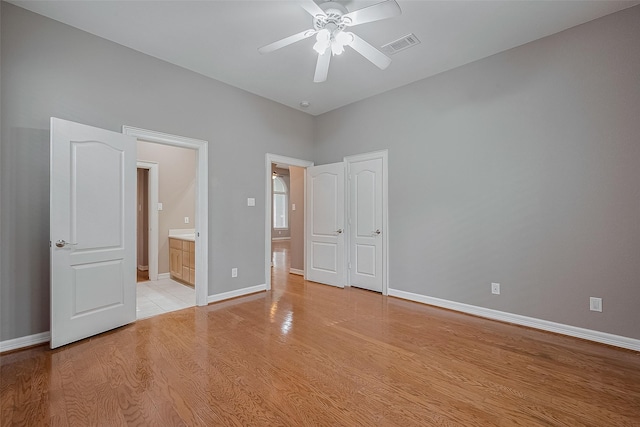 6210 Mahogany Way, Magnolia, TX 77354 - unfurnished bedroom featuring light wood-style flooring, connected bathroom, and a ceiling fan