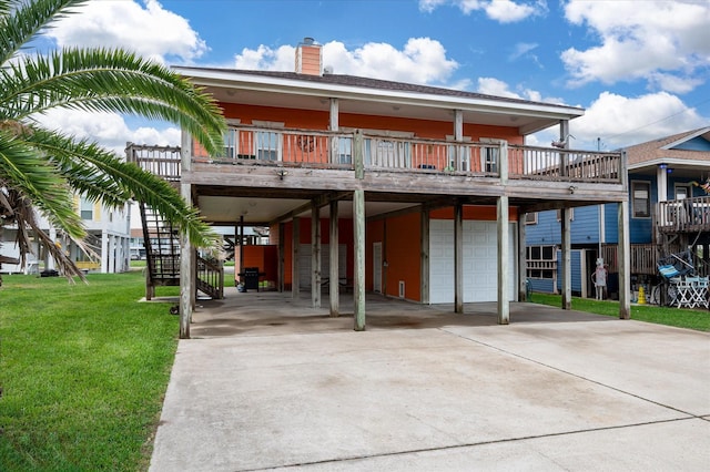 989 Biscayne, Crystal Beach, TX 77650 - back of house featuring stairs, an attached garage, concrete driveway, a chimney, and a yard