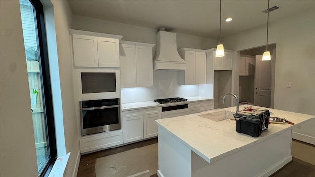 3520 Harvest Dance Dr, Houston, TX 77008 - kitchen with stainless steel appliances, premium range hood, an island with sink, white cabinets, and recessed lighting