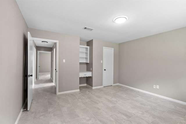 21807 Glenbranch Dr, Spring, TX 77388 - unfurnished bedroom with attic access, built in desk, and light tile patterned floors