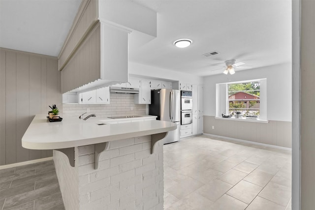 21807 Glenbranch Dr, Spring, TX 77388 - kitchen with stainless steel appliances, light countertops, a peninsula, ceiling fan, and a breakfast bar