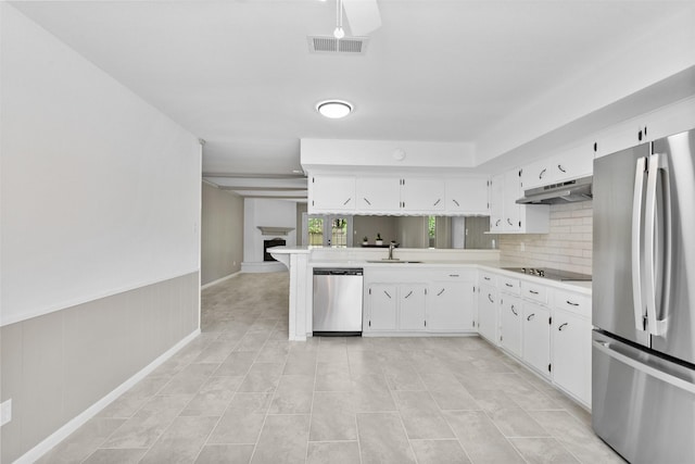 21807 Glenbranch Dr, Spring, TX 77388 - kitchen featuring appliances with stainless steel finishes, under cabinet range hood, light countertops, white cabinetry, and a wainscoted wall