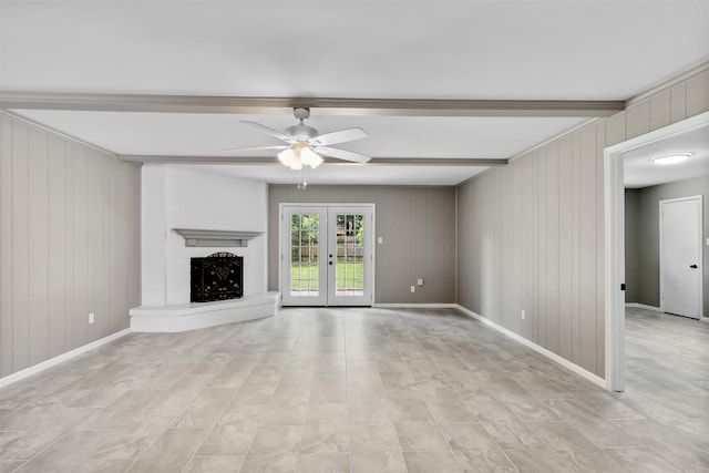 21807 Glenbranch Dr, Spring, TX 77388 - unfurnished living room featuring a ceiling fan, beamed ceiling, wood walls, french doors, and a fireplace with raised hearth