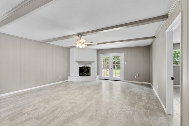 21807 Glenbranch Dr, Spring, TX 77388 - unfurnished living room with ceiling fan, beamed ceiling, healthy amount of natural light, a fireplace with raised hearth, and french doors
