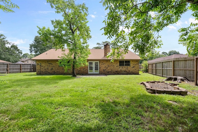 21807 Glenbranch Dr, Spring, TX 77388 - back of property with french doors, brick siding, a fenced backyard, and a chimney