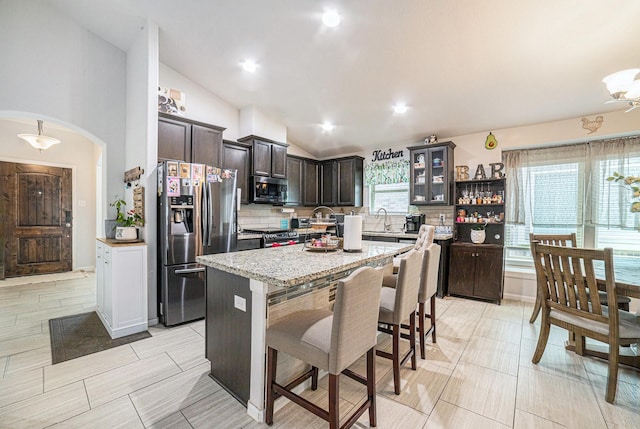 21323 Cypress Live Oak, Cypress, TX 77433 - kitchen with stainless steel appliances, tasteful backsplash, a kitchen breakfast bar, dark brown cabinetry, and a kitchen island