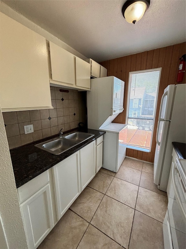 8405 Wilcrest Dr Unit 1606, Houston, TX 77072 - kitchen featuring white appliances, decorative backsplash, a textured ceiling, dark countertops, and wooden walls