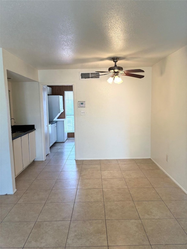 8405 Wilcrest Dr Unit 1606, Houston, TX 77072 - spare room with a ceiling fan, a textured ceiling, and light tile patterned floors