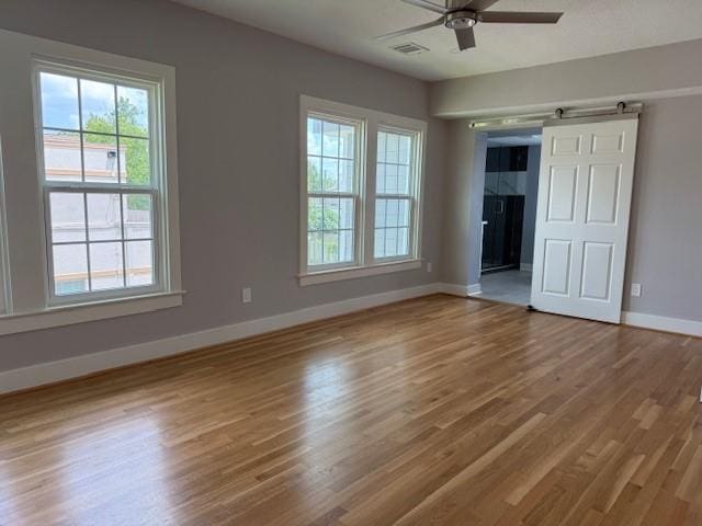 3210 Oakmont St, Houston, TX 77021 - unfurnished bedroom with wood finished floors, multiple windows, and a ceiling fan