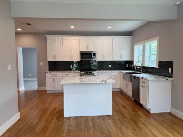 3210 Oakmont St, Houston, TX 77021 - kitchen with appliances with stainless steel finishes, tasteful backsplash, white cabinetry, a kitchen island, and recessed lighting