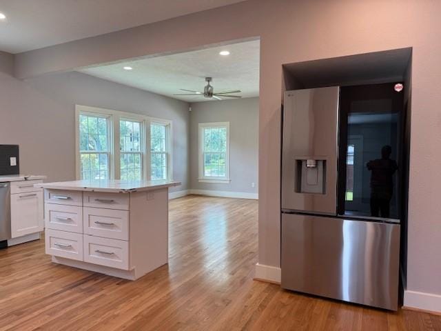 3210 Oakmont St, Houston, TX 77021 - kitchen featuring stainless steel refrigerator with ice dispenser, white cabinets, light countertops, a ceiling fan, and light wood-type flooring