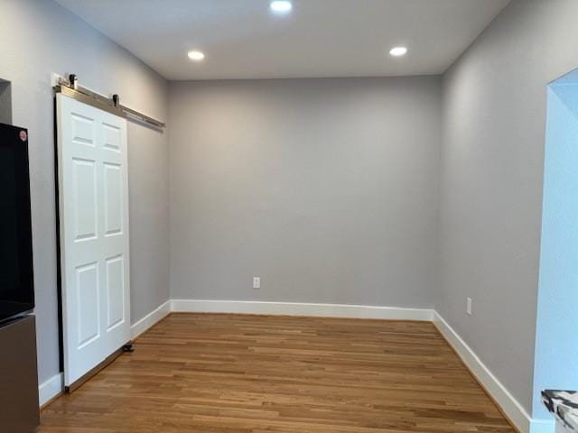 3210 Oakmont St, Houston, TX 77021 - empty room with a barn door, light wood finished floors, and recessed lighting
