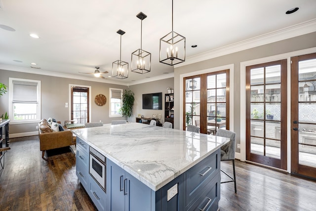 818 Waverly St, Houston, TX 77007 - kitchen with blue cabinets, open floor plan, dark wood finished floors, crown molding, and recessed lighting