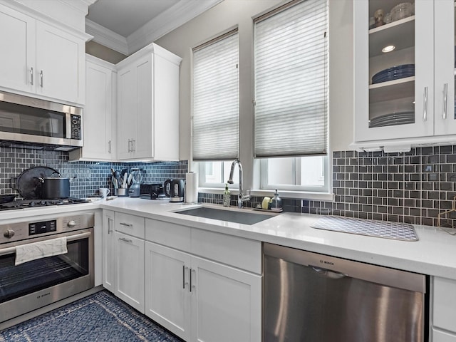 9660 Knight Rd, Houston, TX 77045 - kitchen featuring stainless steel appliances, ornamental molding, light countertops, white cabinets, and backsplash