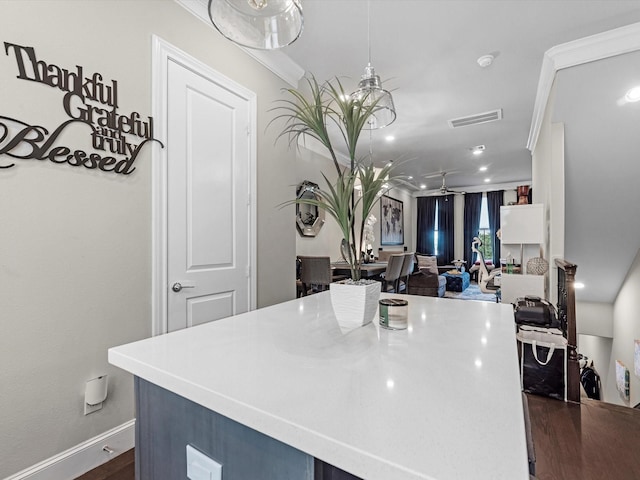 9660 Knight Rd, Houston, TX 77045 - kitchen with ceiling fan, a center island, dark wood-style floors, light countertops, and crown molding