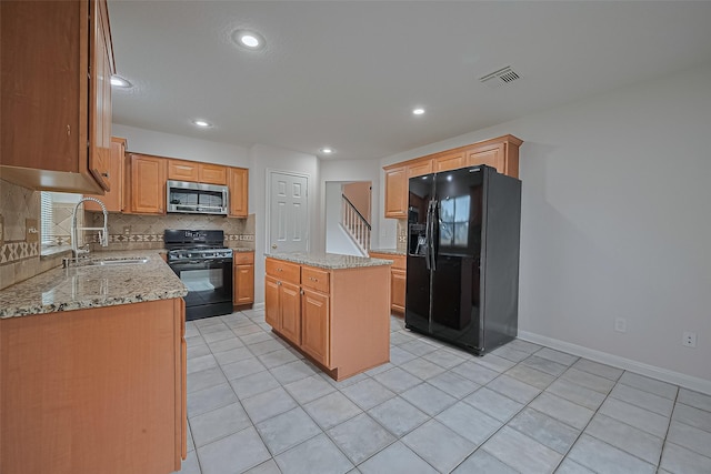 4001 Spring Garden Dr, Pearland, TX 77584 - kitchen with black appliances, decorative backsplash, light stone counters, light tile patterned floors, and a center island