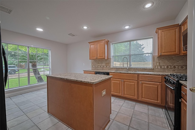 4001 Spring Garden Dr, Pearland, TX 77584 - kitchen featuring black appliances, a center island, backsplash, recessed lighting, and light stone counters