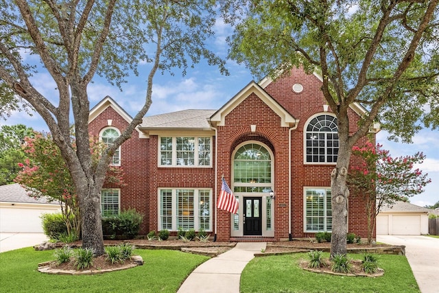 5602 Bergenfield Ct, Katy, TX 77450 - traditional-style house with brick siding, a front lawn, concrete driveway, and a detached garage