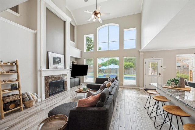 5602 Bergenfield Ct, Katy, TX 77450 - living area with a premium fireplace, a high ceiling, light wood-style floors, ceiling fan, and healthy amount of natural light