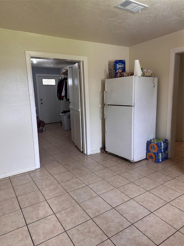 2122 Kowis St, Houston, TX 77093 - kitchen with freestanding refrigerator, a textured ceiling, and light tile patterned floors