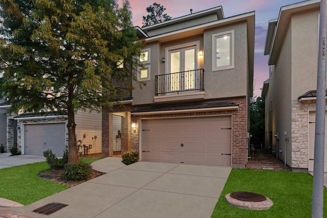 10 Jarvis Row Cir, The Woodlands, TX 77380 - view of front of home featuring a balcony, brick siding, a garage, stucco siding, and concrete driveway