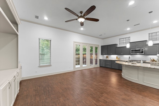 10 Jarvis Row Cir, The Woodlands, TX 77380 - kitchen featuring stainless steel microwave, ceiling fan, recessed lighting, tasteful backsplash, and light stone countertops