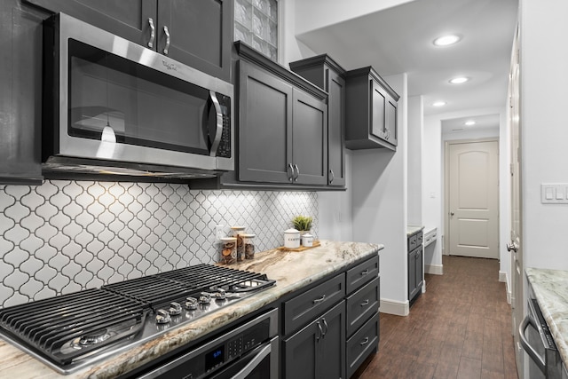 10 Jarvis Row Cir, The Woodlands, TX 77380 - kitchen featuring appliances with stainless steel finishes, decorative backsplash, dark wood-type flooring, light stone counters, and recessed lighting
