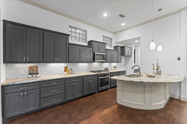 10 Jarvis Row Cir, The Woodlands, TX 77380 - kitchen with stainless steel appliances, ornamental molding, light stone countertops, backsplash, and decorative light fixtures