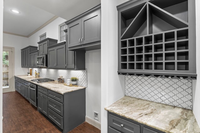 10 Jarvis Row Cir, The Woodlands, TX 77380 - kitchen with dark wood-style floors, backsplash, stainless steel appliances, ornamental molding, and gray cabinetry