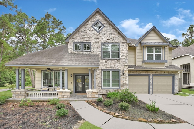 135 Wisteria Walk Cir, The Woodlands, TX 77381 - view of front of home with stone siding, french doors, covered porch, a garage, and concrete driveway