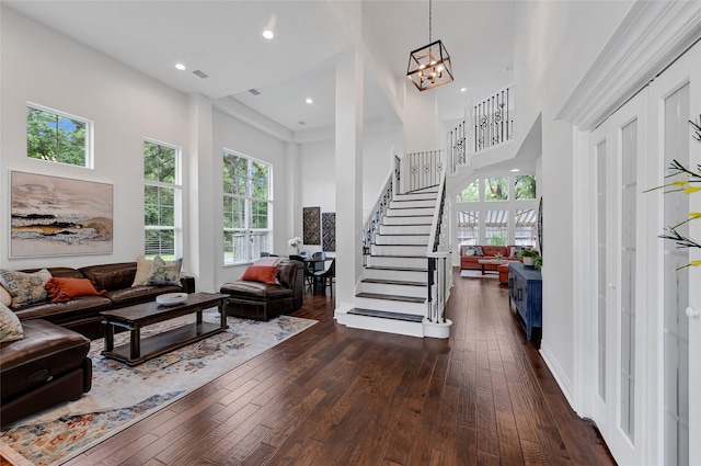 135 Wisteria Walk Cir, The Woodlands, TX 77381 - living area featuring stairway, a towering ceiling, dark wood finished floors, a chandelier, and recessed lighting