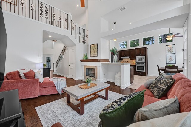 135 Wisteria Walk Cir, The Woodlands, TX 77381 - living area featuring a ceiling fan, stairway, a towering ceiling, light wood finished floors, and recessed lighting