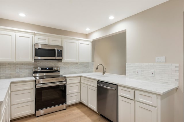 3802 Knollcrest Dr, Montgomery, TX 77356 - kitchen with appliances with stainless steel finishes, backsplash, light wood finished floors, light stone countertops, and recessed lighting