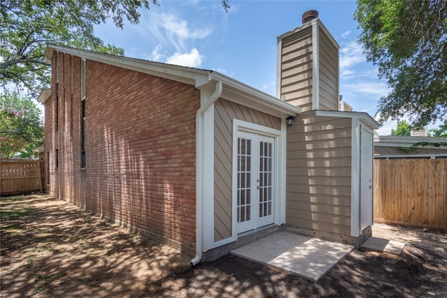 3802 Knollcrest Dr, Montgomery, TX 77356 - view of side of home featuring french doors, a chimney, and brick siding
