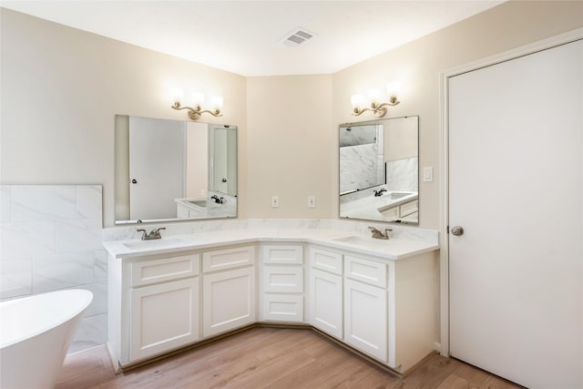 3802 Knollcrest Dr, Montgomery, TX 77356 - bathroom with a soaking tub, double vanity, wood finished floors, a shower, and tile walls