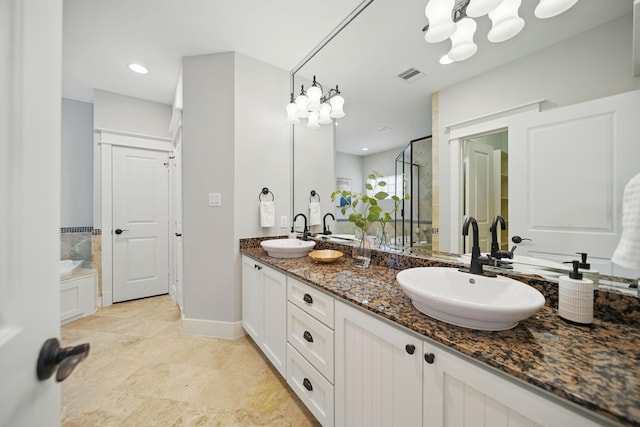 1028 Dunbar St, Houston, TX 77009 - bathroom featuring a stall shower, double vanity, a garden tub, and a chandelier