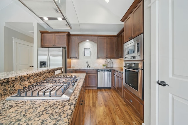 1028 Dunbar St, Houston, TX 77009 - kitchen featuring appliances with stainless steel finishes, light wood-style flooring, tasteful backsplash, light stone countertops, and lofted ceiling