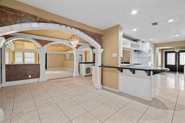7847 Broadview Dr, Houston, TX 77061 - kitchen featuring decorative columns, dark countertops, recessed lighting, a kitchen breakfast bar, and open shelves