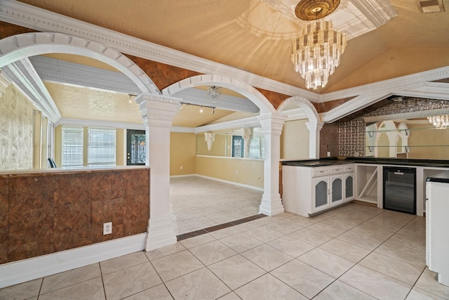 7847 Broadview Dr, Houston, TX 77061 - kitchen featuring ornate columns, wine cooler, healthy amount of natural light, vaulted ceiling, and crown molding