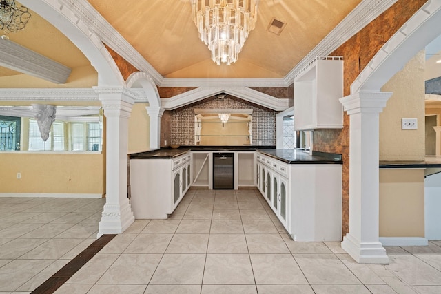 7847 Broadview Dr, Houston, TX 77061 - kitchen with beverage cooler, dark countertops, white cabinetry, and lofted ceiling